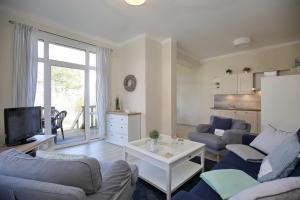 博尔滕哈根Villa Triton Wohnung 01的客厅配有两张沙发和一台电视机