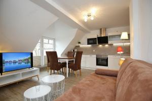 博尔滕哈根Villa Triton Wohnung 05的客厅配有沙发和带电视的桌子