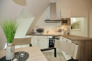 博尔滕哈根Strandvilla Scholle - Aal Wohnung 06的厨房配有白色橱柜和桌椅