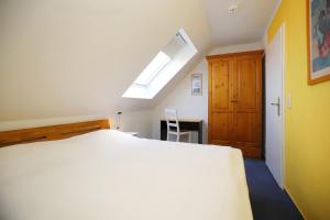 博尔滕哈根Papillon Wohnung 18-6的卧室配有白色的床和天窗