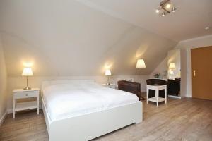 博尔滕哈根Strandvilla Krabbe Wohnung 13的一间带白色床的卧室和一间客厅