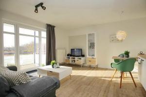 博尔滕哈根Haffblick Wohnung 42的客厅配有沙发和桌子