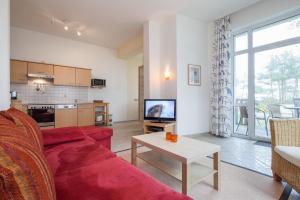 博尔滕哈根Villa Triton Wohnung 02的客厅配有红色的沙发和桌子