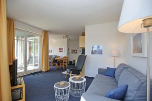 博尔滕哈根Dünenblick Wohnung 24的客厅配有蓝色的沙发和桌子