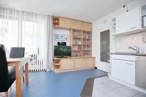 博尔滕哈根Likedeeler Wohnung 12的厨房配有水槽、电视和桌子