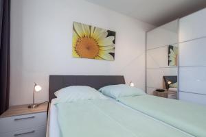 博尔滕哈根Sünnslag Wohnung 039的卧室配有一张挂有花卉画的床铺。