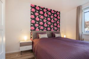 博尔滕哈根Sünnslag Wohnung 097的一间卧室配有一张紫色床和花卉床头板