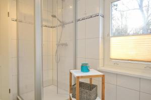 博尔滕哈根Strandvilla Krabbe Wohnung 02的带淋浴的浴室以及带凳子的桌子
