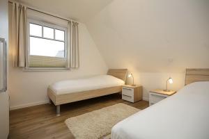 博尔滕哈根Reethaus Am Mariannenweg 17a的一间卧室设有两张床和窗户。