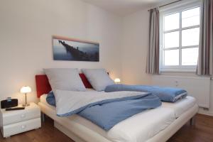 海利根达姆Residenz von Flotow Wohnung 09的一间卧室配有蓝色和白色床单