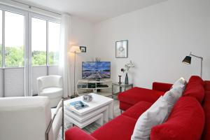 海利根达姆Residenz von Flotow Wohnung 14的客厅配有红色沙发和电视
