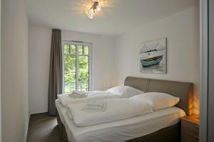海利根达姆Linden-Palais Wohnung 06的一间卧室设有两张带白色床单的床和窗户。