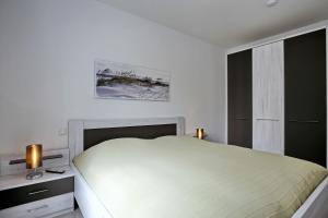 海利根达姆Linden-Palais Wohnung 20的白色的卧室设有床和窗户