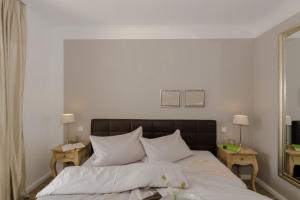 伯尔格伦德-雷特维施Villa Sanddorn Wohnung 11的一间卧室配有一张带白色床单的床和两张桌子