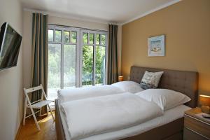 海利根达姆Linden-Palais Wohnung 38的一间卧室设有两张白色的床和窗户