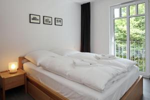 海利根达姆Linden-Palais Wohnung 21的窗户客房内的一张白色床