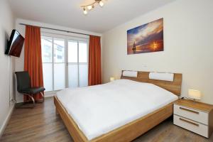 伯尔格伦德-雷特维施Villa Strandvogt Wohnung 11的一间卧室设有一张大床和一个窗户。