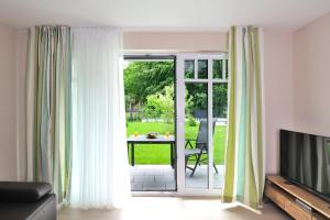 海利根达姆Linden-Palais Wohnung 11的客厅配有推拉玻璃门和桌子