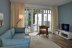 海利根达姆Linden-Palais Wohnung 26的客厅配有蓝色的沙发和电视