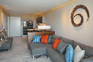 海利根达姆Linden-Palais Wohnung 01的客厅配有带色彩缤纷枕头的灰色沙发