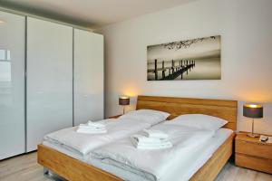 海利根达姆Linden-Palais Wohnung 16的一间卧室配有一张带白色床单和两盏灯的床。