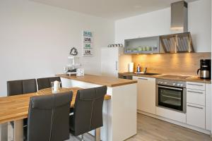 海利根达姆Linden-Palais Wohnung 16的厨房配有木桌和台面
