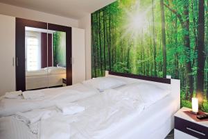 海利根达姆Linden-Palais Wohnung 02的一间卧室配有一张白色床和绿色森林壁画