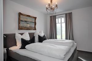 海利根达姆Linden-Palais Wohnung 30的一间卧室配有两张床和吊灯。