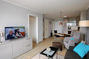 海利根达姆Linden-Palais Wohnung 15的客厅配有白色橱柜上的平面电视