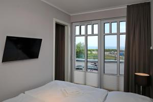海利根达姆Linden-Palais Wohnung 15的酒店客房设有一张床和一个大窗户