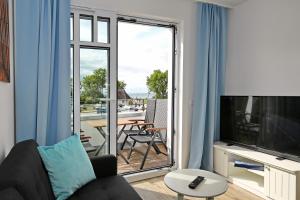 海利根达姆Linden-Palais Wohnung 31的带沙发和电视的客厅以及阳台。