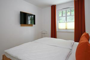 海利根达姆Linden-Palais Wohnung 13的一间卧室配有一张床,墙上配有电视