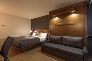 魁北克市魁北克N酒店的一间卧室配有一张床和一个沙发