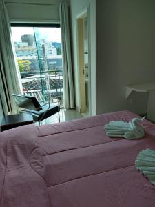 圣洛伦索阿尔兹拉广场酒店的卧室设有一张粉红色的大床和一扇窗户。