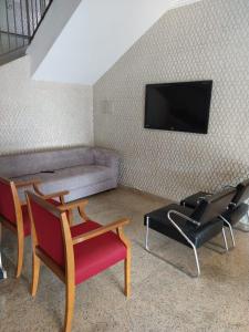 圣洛伦索阿尔兹拉广场酒店的客厅配有两把椅子和一张沙发