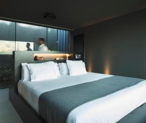 贝尼曼特利VIVOOD Landscape Hotel & Spa - Designed for Adults的卧室内的一张带白色枕头的大床