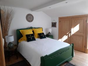 Saint-Rambert-en-BugeyLA KAIGA的一间卧室配有绿色的床和黄色枕头