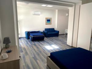 费拉约港Appartamenti Acquazzurra的一间设有两张蓝色椅子、一张床和一张沙发的房间