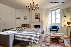 瓦讷Appartements de caractère centre的一间卧室配有一张床、一把椅子和一个吊灯。
