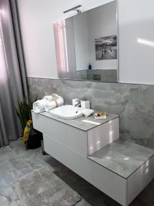 马拉内罗B&B LA ROSA GIALLA的浴室设有白色水槽和镜子