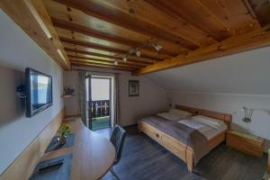 魏勒格费瑞恩霍农加格公寓的一间卧室设有一张床和木制天花板