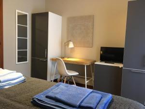 博尔戈马内罗Le Camere di Garibaldi的一间卧室配有书桌和一张带蓝毛巾的床。