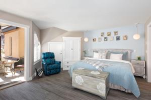 惠斯勒Renovated & Spacious 1bed/2bath Whistler Village的一间卧室配有一张床和一张蓝色椅子