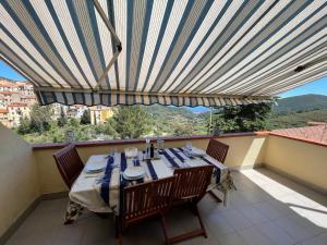 里奥内莱尔巴VerdeMare的阳台配有桌椅和大雨伞