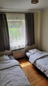 GabońAgroturystyka "RYVILLA"的带窗户的客房内的两张床