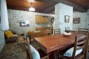 科帕罗Seaside Duplex Stone Villa的厨房以及带木桌的用餐室。