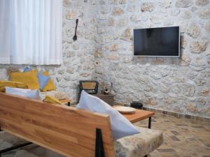 科帕罗Seaside Duplex Stone Villa的客厅配有沙发和石墙电视。