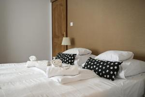 托考伊华斯克佩泽欧酒窖酒店的白色的床、白色枕头和草编织品