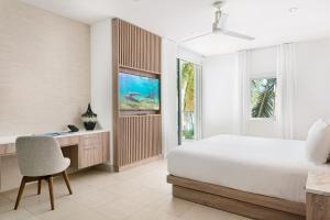 格雷斯湾Wymara Resort & Villas的一间卧室配有一张床、一张桌子和一把椅子