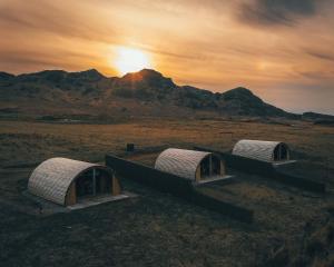 阿卡莱克Volcano Cabins的三个圆顶,在地表上呈日落
